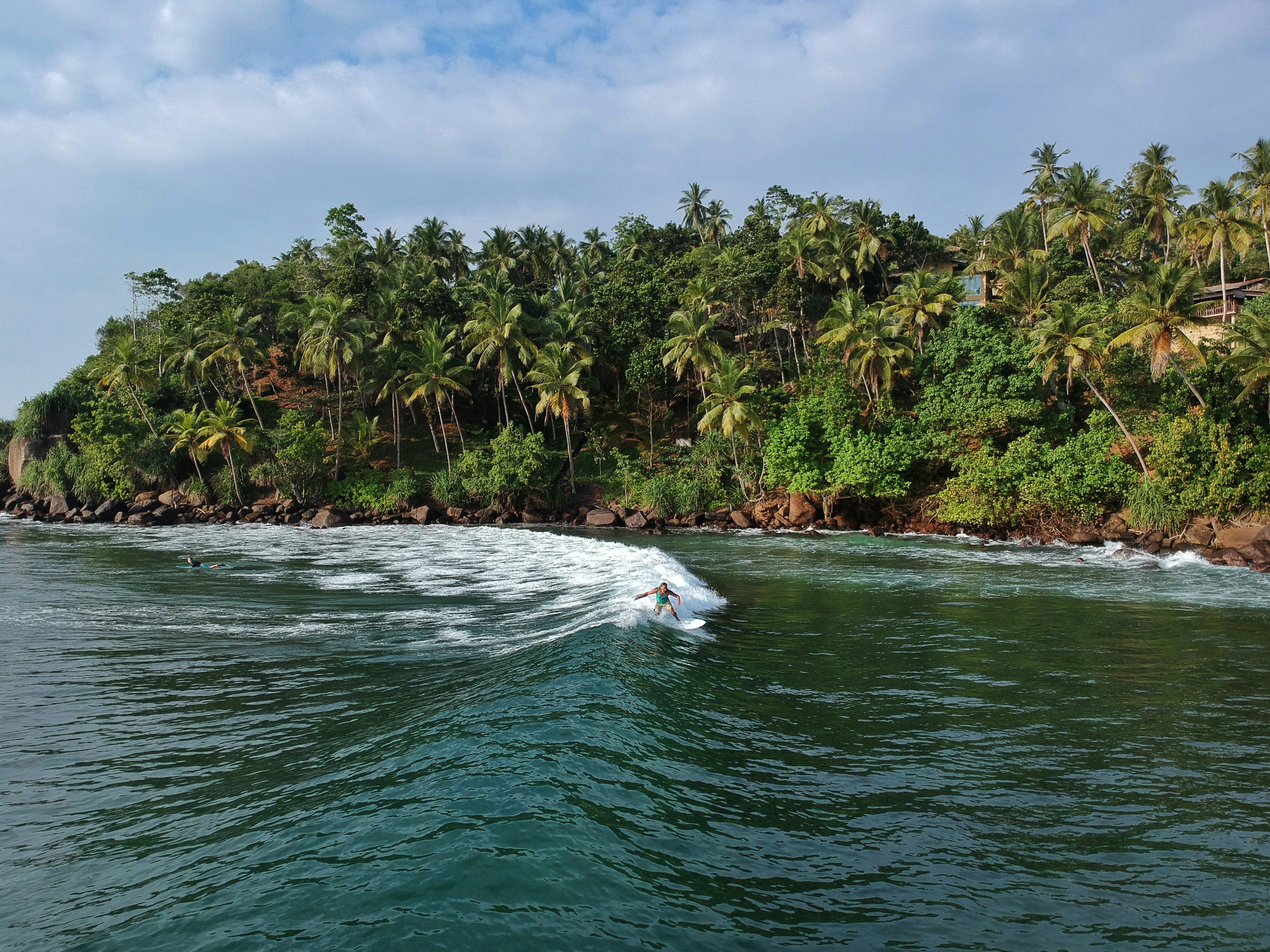 School Surf Trips to Sri Lanka. Man surfing on waves